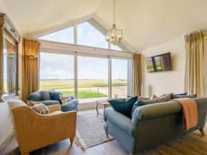 a living room with two couches and a large window at 1 Pheasant in East Ilsley