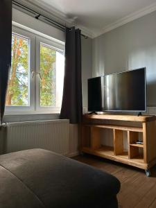 a living room with a flat screen tv on a table at Rustic Charm - Cottage by Comfort Housing in Kolonie Neudöberitz