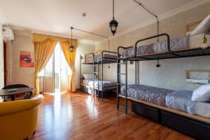 ローマにあるOstello Bello Roma Colosseoの二段ベッド3台とソファが備わる客室です。