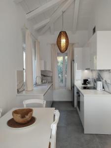 een keuken met witte kasten en een tafel met een kom erop bij Luxury Apartments La Villa in Chorto