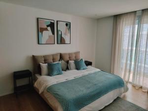 a bedroom with a large bed with blue pillows at Cosy apartment with terrasse at in CFC in Casablanca