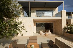 a house with a patio with chairs and tables at Luxury Stone Houses Corfu in Píthos