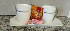 dos tazas en una bandeja con un paquete de leche en Los Manzanares, monoambiente, en Veintiocho de Noviembre