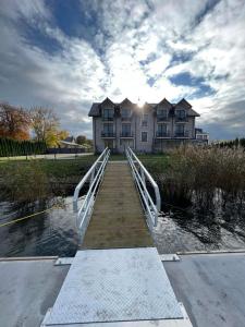 a bridge over a body of water in front of a house at Willa Aura Mare in Dziwnów