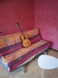 a guitar sitting on top of a couch at La Casa di Boh, vicino ospedale San Paolo, Iulm, Forum Assago in Milan