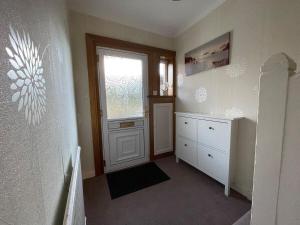 a room with a door and a dresser and a window at 1930s 3Bed House in Quiet Village w/ Large Garden in Bishopton