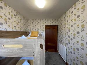 Habitación pequeña con 2 camas y puerta en 1930s 3Bed House in Quiet Village w/ Large Garden, en Bishopton