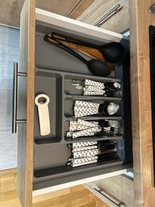 a drawer in a cabinet filled with cooking utensils at 2 rooms apartment Airy & Bright Chic in Iaşi