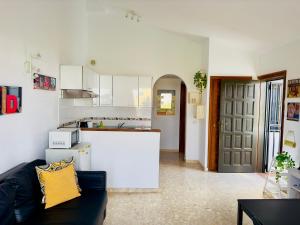 sala de estar con sofá y cocina en Oasis Retreat 793 - Appartamento con piscina a Amarilla Golf, en San Miguel de Abona