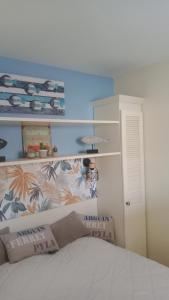 1 dormitorio con cama blanca y pared azul en BLEU MARINE Vue sur l'Océan, en Lacanau-Océan