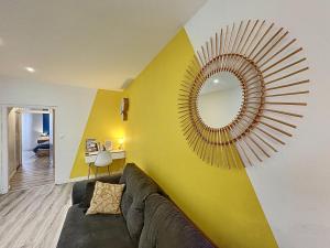 ein Wohnzimmer mit einem Sofa und einem Spiegel in der Unterkunft Confort, wifi et garage in Millau