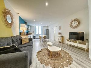 a living room with a couch and a table at Confort, wifi et garage in Millau