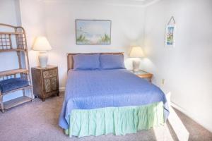 a bedroom with a blue bed with two lamps and a ladder at Carol Bay 503 in Myrtle Beach