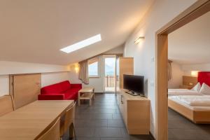 Habitación de hotel con cama y sofá rojo en Der Blaue Reiter, en Scena