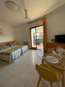 a bedroom with a bed and a table and a television at Apartamentos El Sol in Tossa de Mar