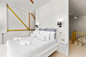 a white bedroom with a bed with white pillows at Loft on Hope in Cape Town