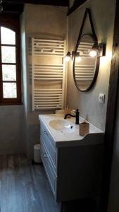 ein Bad mit einem Waschbecken und einem Spiegel in der Unterkunft Ancien moulin atypique proche de Toulouse in Lavaur