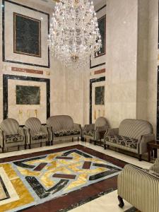 salon z kanapami i żyrandolem w obiekcie فندق بنيان العزيزية w Mekce