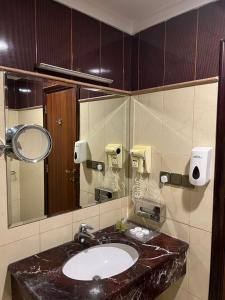 W łazience znajduje się umywalka i lustro. w obiekcie فندق بنيان العزيزية w Mekce