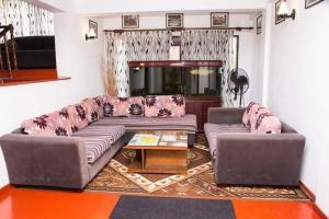 una sala de estar con un sofá y una mesa en Villa 107, en Kandy
