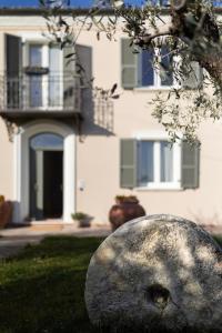 a rock sitting in the grass in front of a house at Palazzo Gessi Room and Breakfast in Borghi