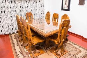 a wooden dining room table with wooden chairs around it at Villa 107 in Kandy