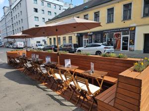 una fila di tavoli e sedie con ombrellone di St Christopher's Inn Vienna a Vienna