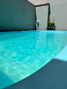uma piscina com água azul e um guarda-sol em HANNA Balneário Hotel em Balneário Camboriú