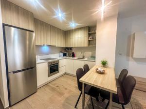 a kitchen with a table and a stainless steel refrigerator at La Mata dream in La Mata