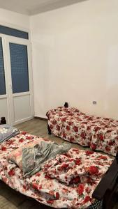 2 camas sentadas en una habitación con una puerta en Plage à 500 mètres! Appartement familial paisible avec vue sur mer à Melbou, idéal pour des vacances relaxantes. en Les Falaises