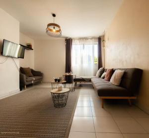 - un salon avec un canapé et une télévision dans l'établissement La colline - piscine et tennis, à Montpellier