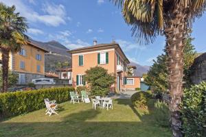 ein Haus mit einem Tisch und Stühlen im Hof in der Unterkunft La Rossa Camelia in Cannobio