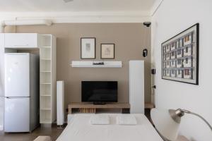 Una sala de estar con refrigerador y televisor. en Elegante Bilocale in Zona Risorgimento, en Milán