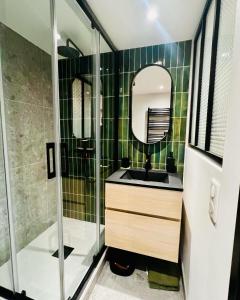 a green tiled bathroom with a sink and a shower at Superbe studio neuf - 20 min Versailles (jo2024) in Les Clayes-sous-Bois +16 photos