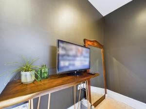 a flat screen tv sitting on top of a wooden table at La Cassa Rossa Pittville Central Parking Modern Wifi in Cheltenham