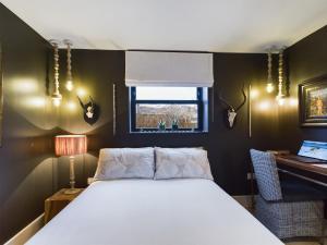 a bedroom with a bed and a desk and a window at La Cassa Rossa Pittville Central Parking Modern Wifi in Cheltenham