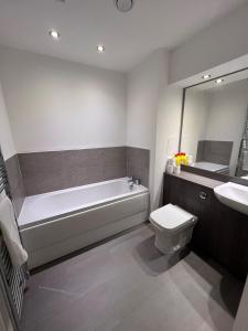 łazienka z wanną, toaletą i umywalką w obiekcie Modern 2 Bedroom Flat in Quiet Village w/ Ensuite w mieście Bishopton