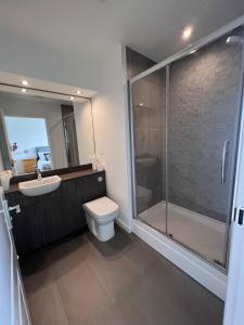 W łazience znajduje się prysznic, toaleta i umywalka. w obiekcie Modern 2 Bedroom Flat in Quiet Village w/ Ensuite w mieście Bishopton