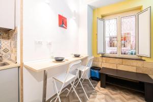 uma cozinha com mesa e cadeiras e uma janela em Room21 By DomusExtra em Nápoles