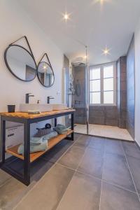 ein Bad mit einem Waschbecken und einem Spiegel in der Unterkunft Les gîtes du château in Bouhet