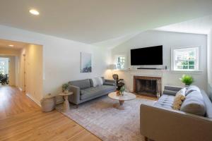 uma sala de estar com um sofá e uma lareira em Heated Pool, Driftwood Cottage by RoveTravel em East Hampton