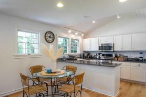 a kitchen with a table and chairs and a clock at Heated Pool, Driftwood Cottage by RoveTravel in East Hampton