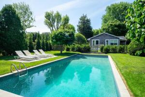 uma piscina no quintal de uma casa em Heated Pool, Driftwood Cottage by RoveTravel em East Hampton