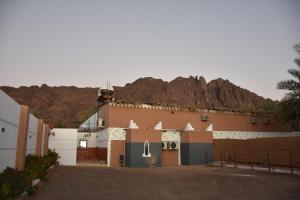 a large building with a mountain in the background at منتجع ريف خزيمة - الفيروز in Al Madinah