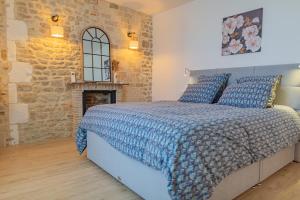 ein Schlafzimmer mit einem Bett und einer Steinmauer in der Unterkunft Les gîtes du château in Bouhet