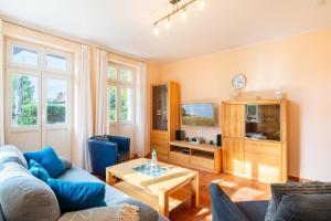 a living room with a couch and a table at Hochwertig einger. Fewo mit Sonnenterrasse, Veranda, in Strandnähe in Kühlungsborn