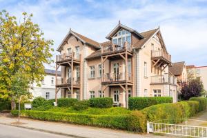 a large apartment building with balconies and bushes at Hochwertig einger. Fewo mit Sonnenterrasse, Veranda, in Strandnähe in Kühlungsborn +5 photos