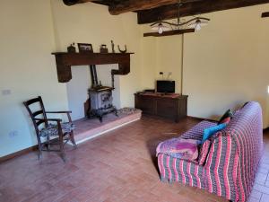 sala de estar con sofá y chimenea en bacciano casa vacanze, en Poggio