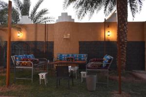 a group of chairs and tables in front of a wall at منتجع ريف خزيمة - الفيروز in Medina