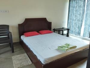 een bed met twee rode kussens in een slaapkamer bij Née Barsha residency in Puri
